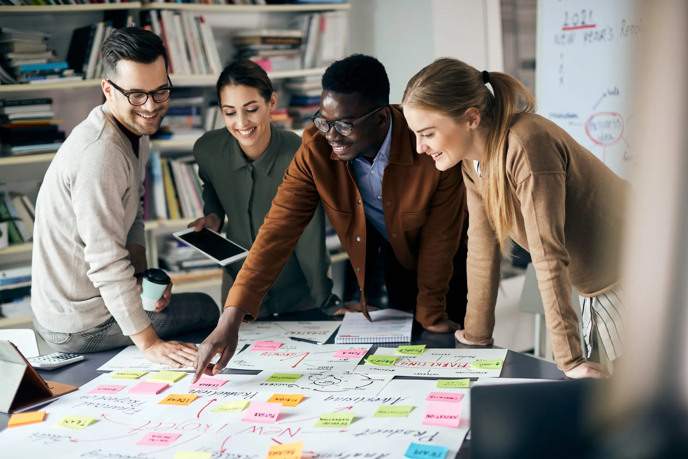 A diverse team of professional colleagues collaborating on a strategic project roadmap around a table.